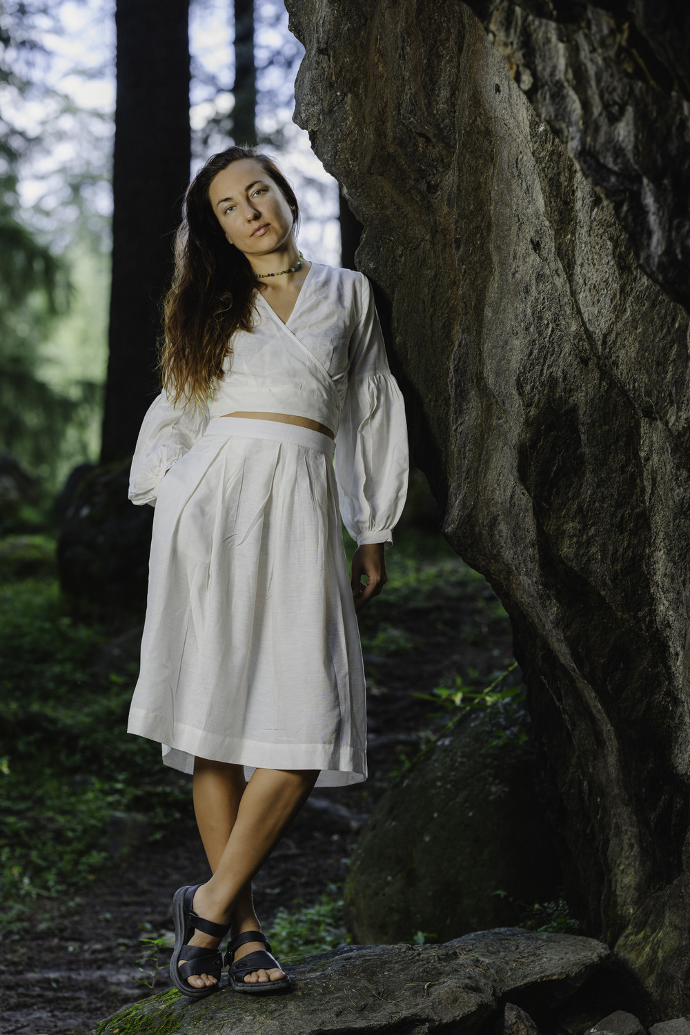 A woman in a natural setting, wearing a long, flowy white skirt in soft cotton linen. She is 5'8" tall and wearing a size M.