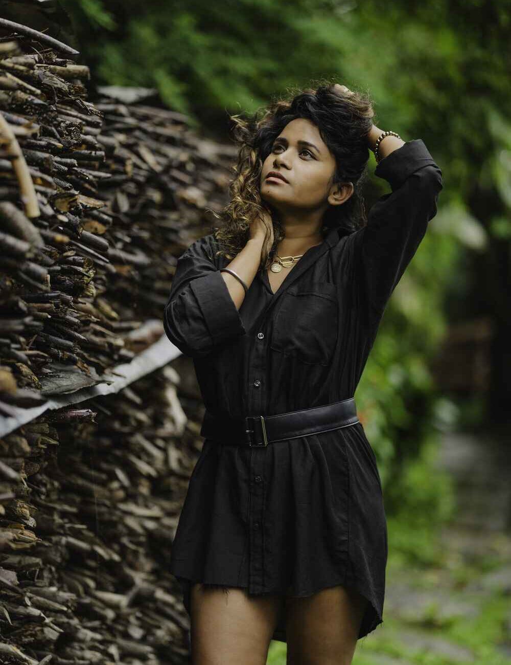 Model wearing a black linen cotton shirt dress with a button-down closure and a belt on the front.