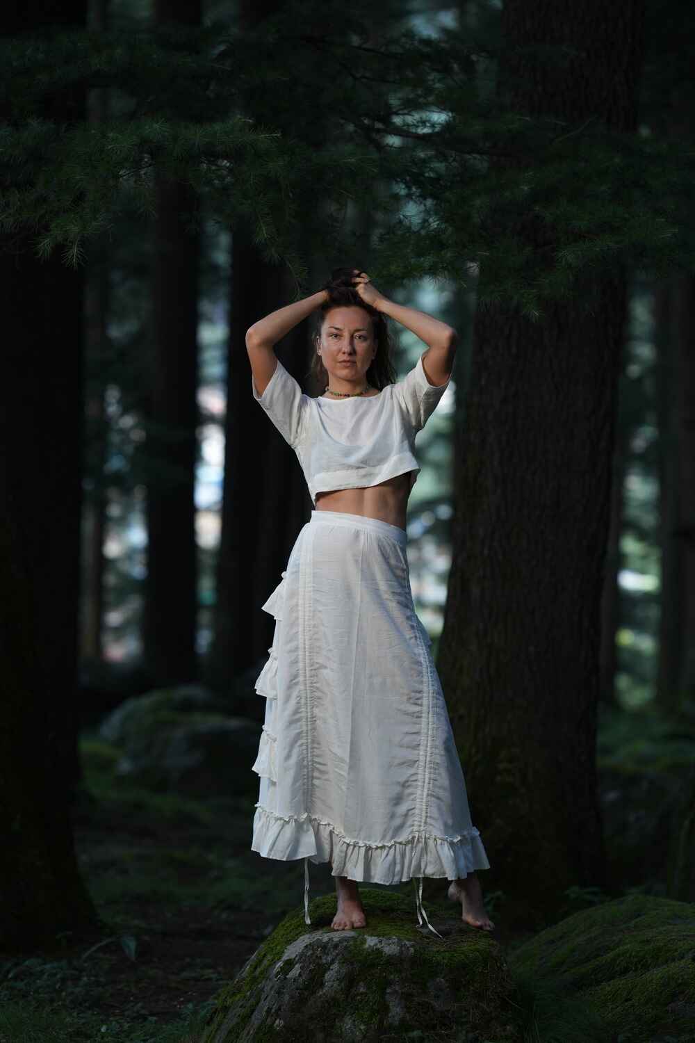 Model wearing a chic white cotton linen crop top with a wrap-around design.