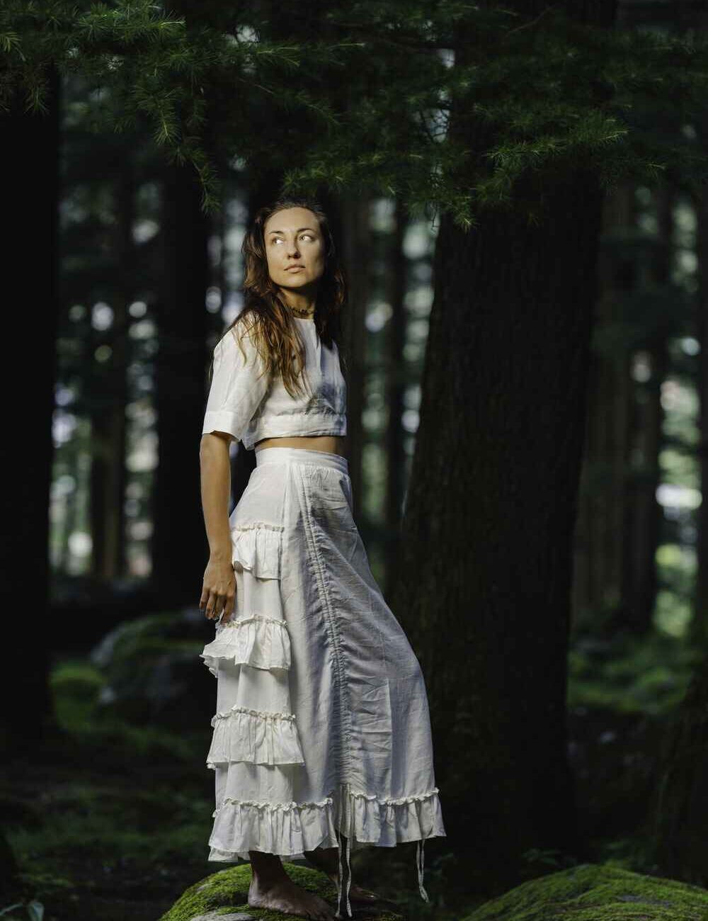 Model wearing a beautiful white cotton linen skirt with ruffles and a flowing design.