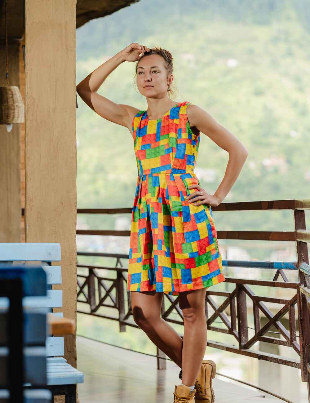 Model wearing a vibrant sleeveless, short dress for women in multi-color baby satin fabric.