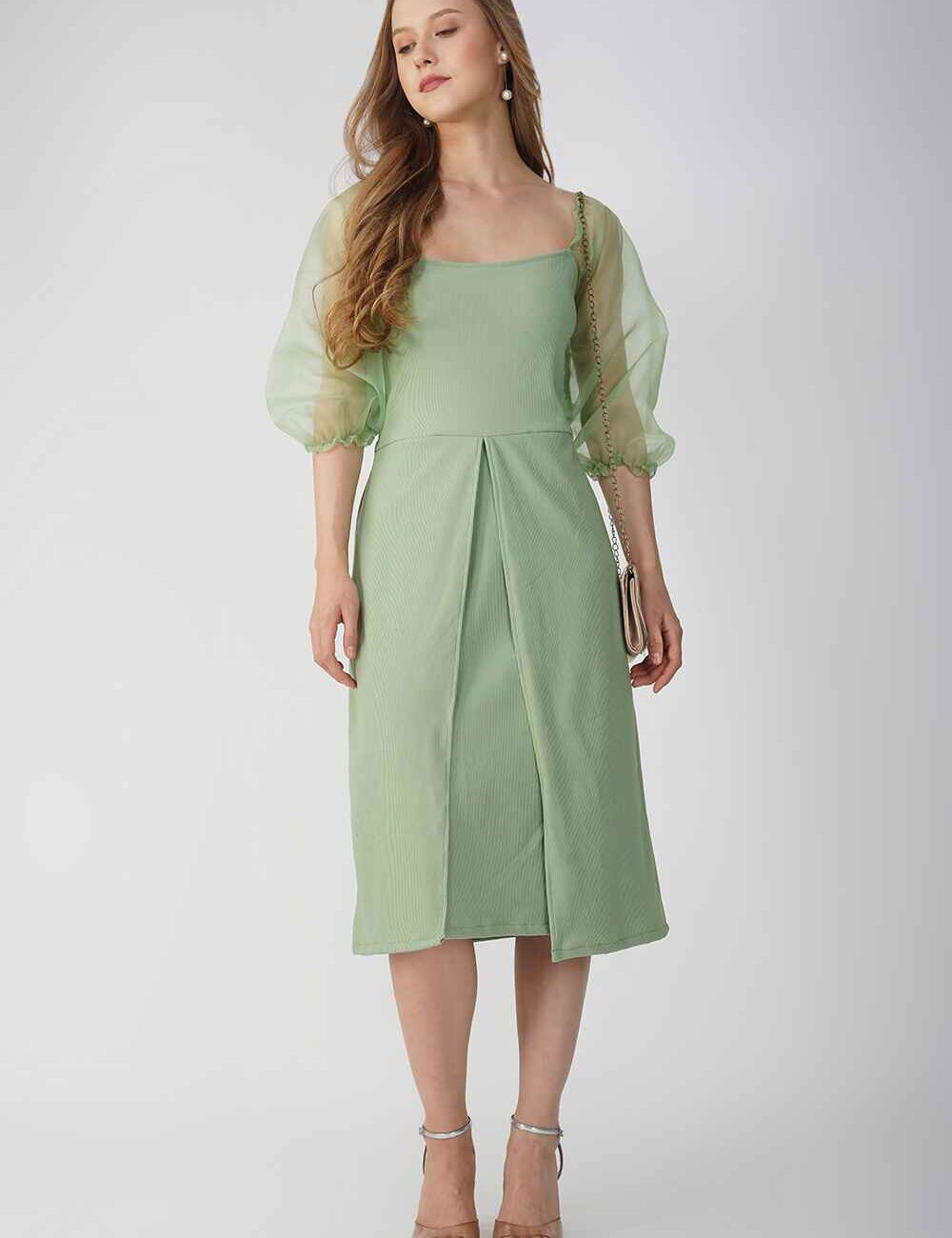 Model wearing a light green casual dress with sheer sleeves and a soft, flowing design.