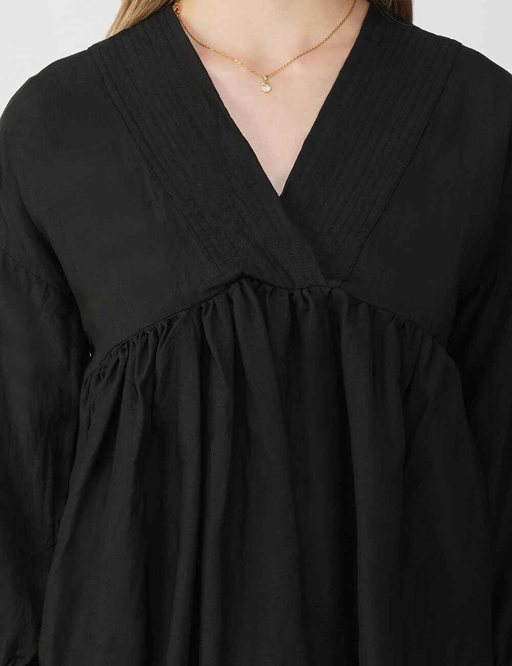 Black cotton-linen peplum top with a v-neckline and relaxed, flowy structure.