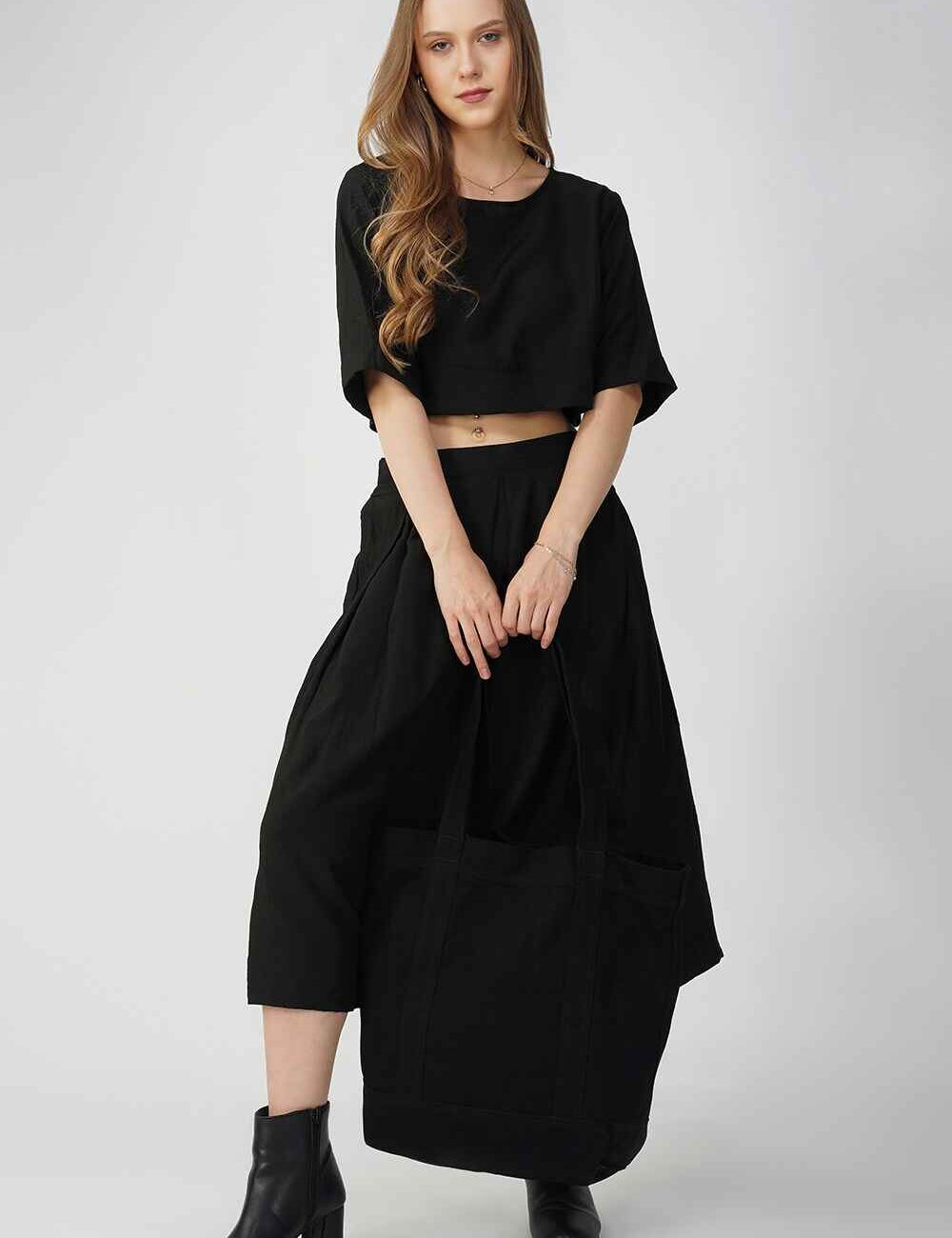 A woman wearing a black cotton linen midi skirt with a relaxed fit.