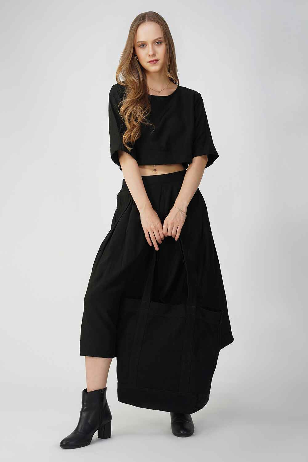 A woman wearing a black cotton linen midi skirt with a relaxed fit.