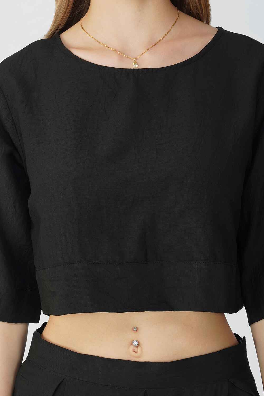 A woman wearing a black cotton linen crop top. She is 5'6" tall, wearing a size M.