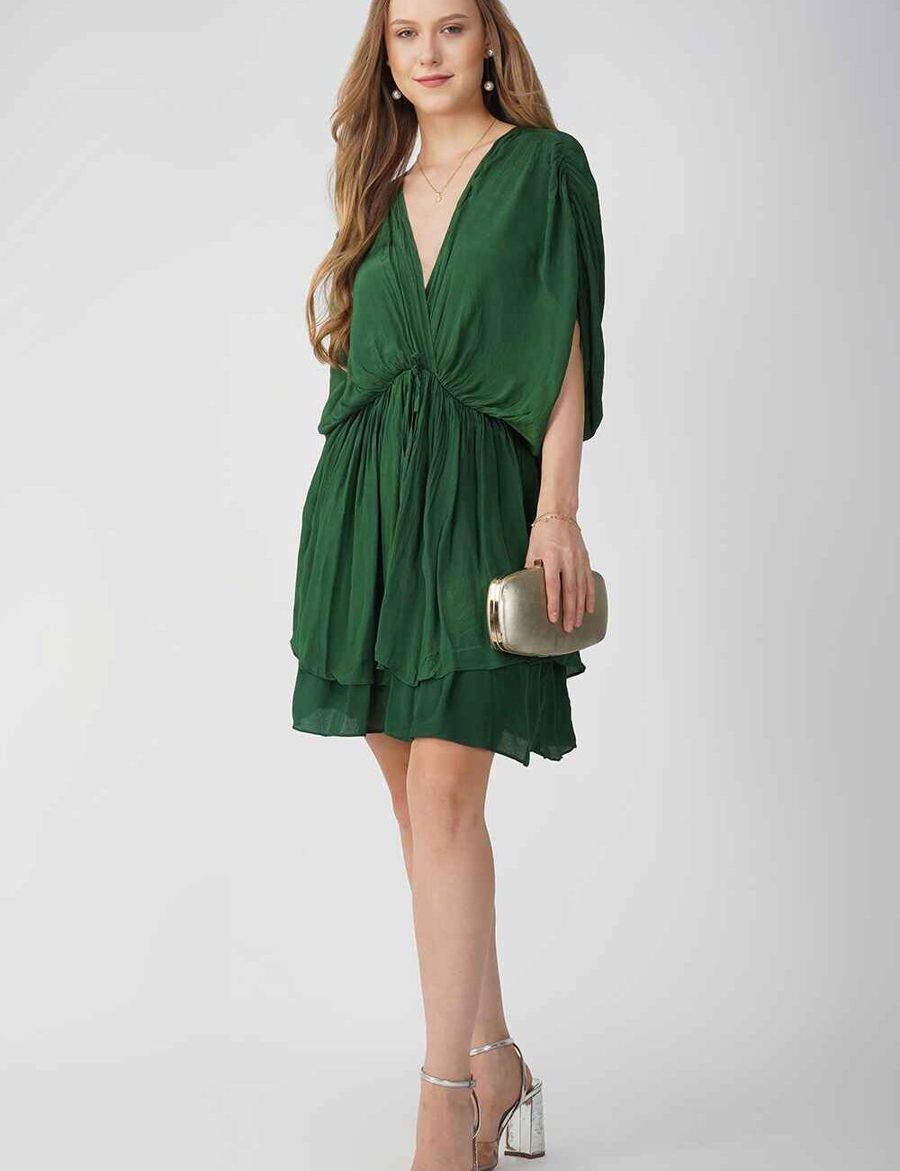 Model wearing a green V-neck party dress with a relaxed fit and layered skirt.