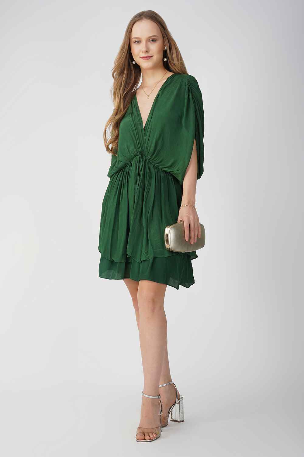 Model wearing a green V-neck party dress with a relaxed fit and layered skirt.